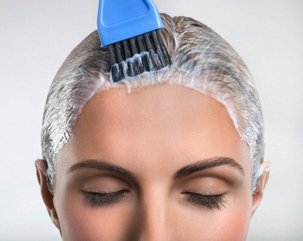 Young woman applying hair color --- Image by © Marc Vuillermoz/Onoky/Corbis